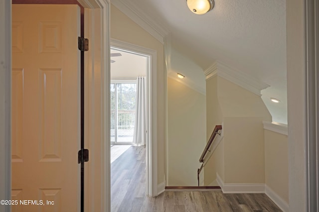 hallway featuring wood finished floors, an upstairs landing, and baseboards