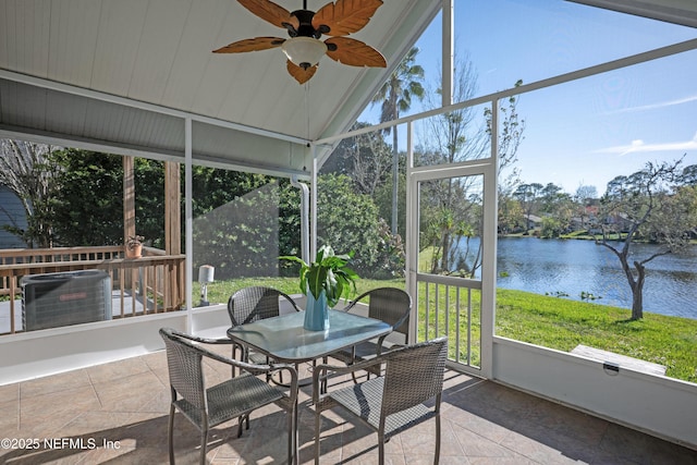 sunroom / solarium featuring a ceiling fan, lofted ceiling, and a water view