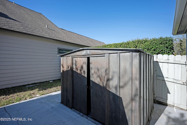 view of shed featuring fence