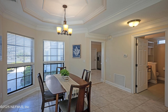 dining space with light tile patterned floors, a chandelier, visible vents, baseboards, and a tray ceiling