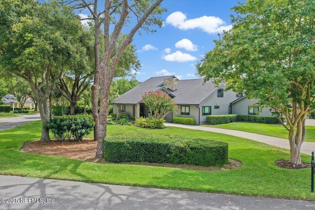 view of front of property with curved driveway and a front lawn