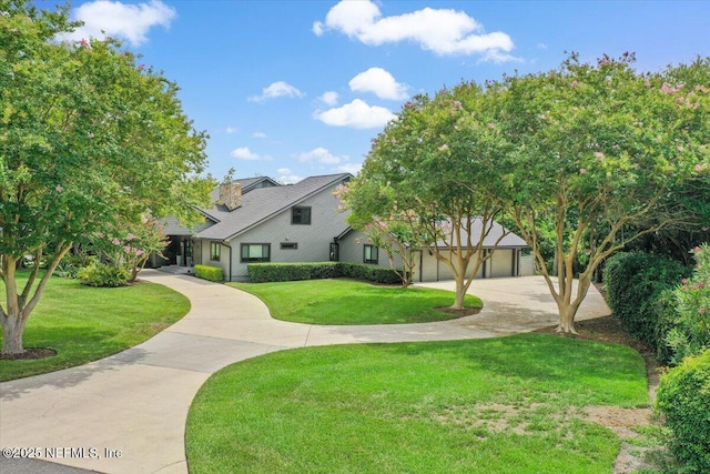 view of front facade featuring a garage, concrete driveway, and a front yard