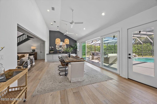 living area featuring a ceiling fan, visible vents, high vaulted ceiling, light wood-style flooring, and a sunroom