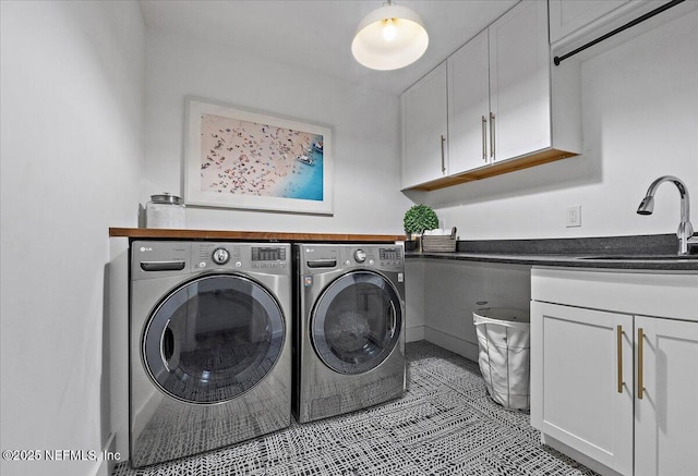 laundry room featuring cabinet space, light tile patterned flooring, separate washer and dryer, and a sink