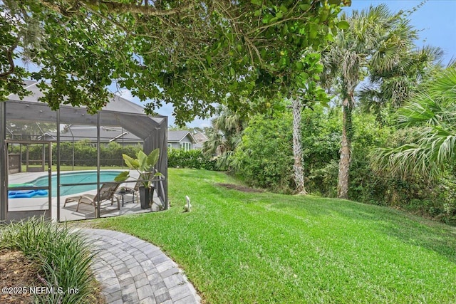 view of yard featuring an outdoor pool, glass enclosure, and a patio