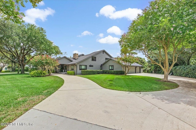 view of front of property featuring a front lawn, a garage, and curved driveway