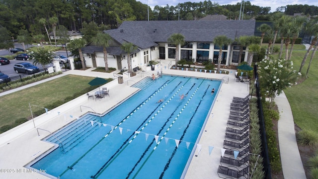 pool with a patio area, a yard, and fence