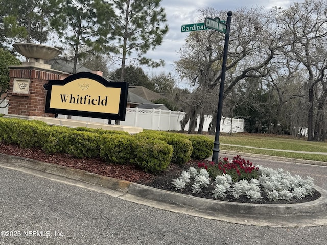 community / neighborhood sign with fence