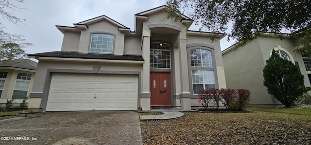 view of front of home with a garage, concrete driveway, and stucco siding