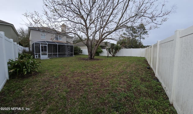 view of yard with a sunroom and a fenced backyard