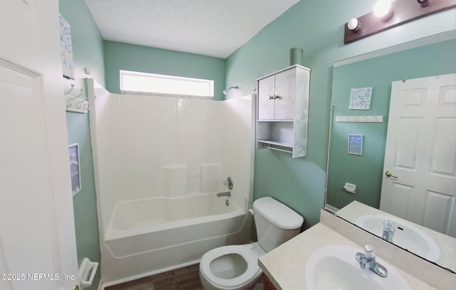 full bathroom featuring a textured ceiling, shower / tub combination, toilet, wood finished floors, and vanity