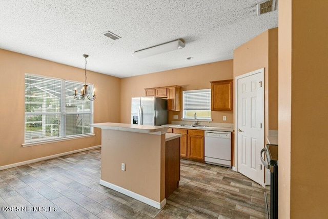 3925 Leatherwood Dr, Orange Park, FL 32065 - kitchen featuring stainless steel refrigerator with ice dispenser, dishwasher, a sink, wood finished floors, and a textured ceiling
