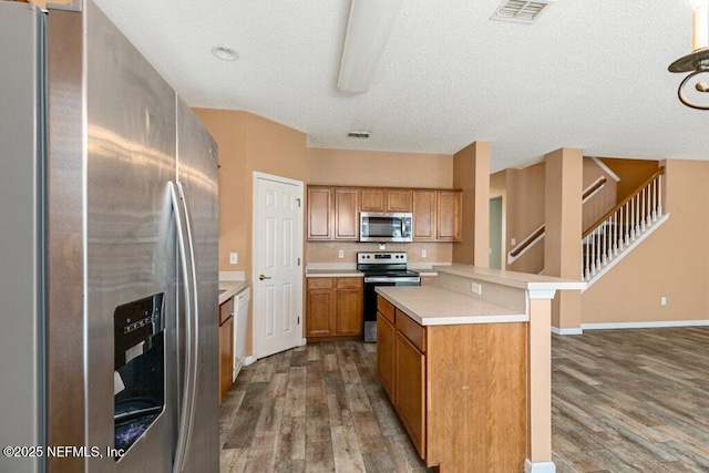 3925 Leatherwood Dr, Orange Park, FL 32065 - kitchen featuring appliances with stainless steel finishes, wood finished floors, light countertops, a center island, and a textured ceiling