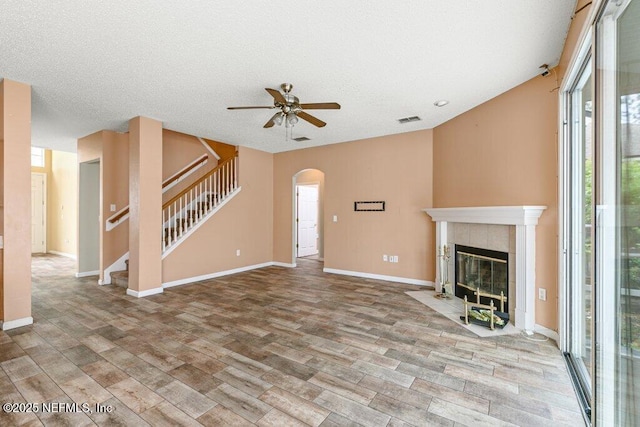 3925 Leatherwood Dr, Orange Park, FL 32065 - unfurnished living room with ceiling fan, wood finished floors, arched walkways, stairs, and a fireplace