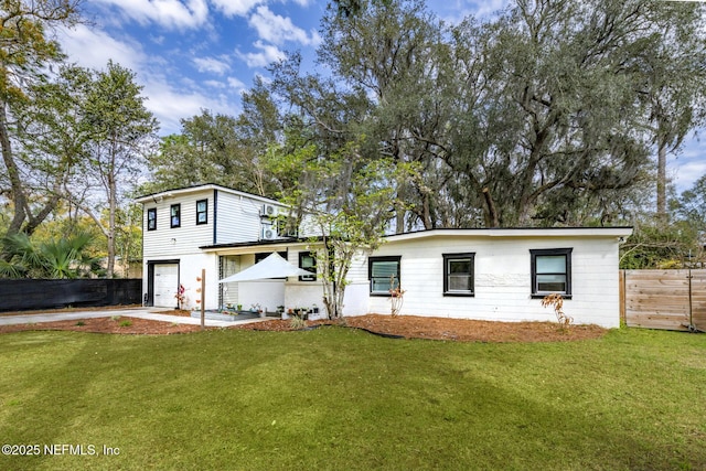 view of front of property with a garage, a front lawn, and fence