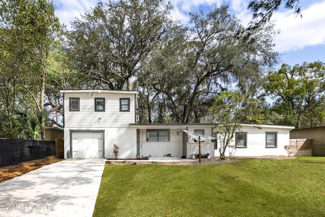 view of front of property featuring a garage, driveway, a front lawn, and fence