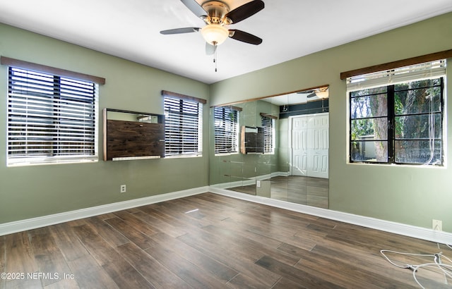 spare room featuring ceiling fan, baseboards, and wood finished floors