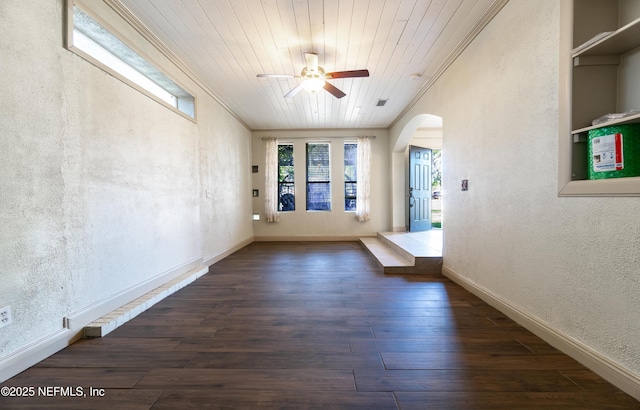 unfurnished room featuring arched walkways, a textured wall, ornamental molding, ceiling fan, and wood finished floors