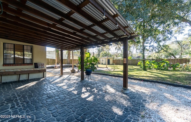 view of patio / terrace with an outbuilding, a shed, and a fenced backyard