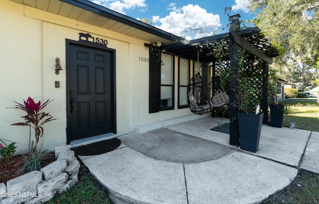 doorway to property featuring stucco siding