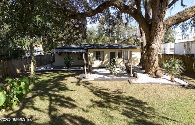 rear view of house with a yard, a patio area, and a fenced backyard