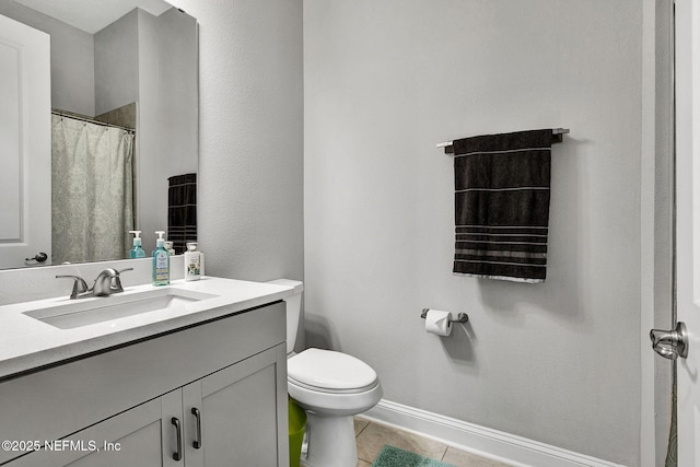 full bathroom featuring baseboards, toilet, vanity, and tile patterned flooring