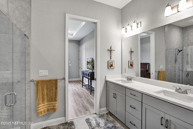 bathroom with a sink, a shower stall, ensuite bathroom, and double vanity