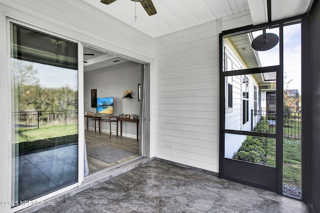 unfurnished sunroom featuring ceiling fan