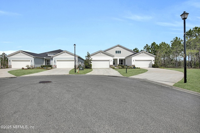 ranch-style house featuring a garage, concrete driveway, and a front lawn