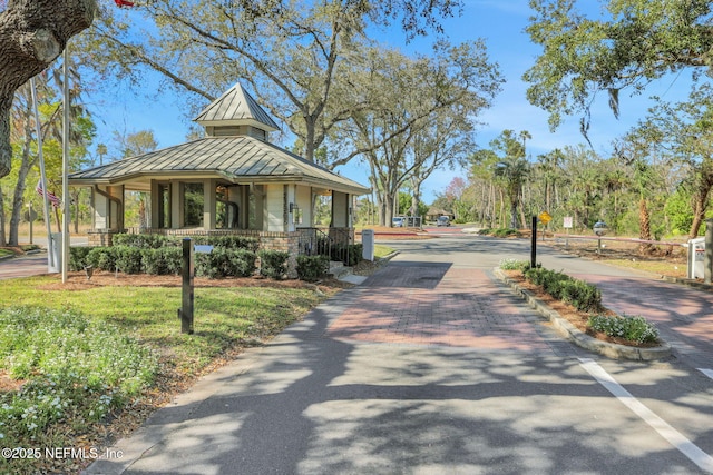 view of front of property with a standing seam roof, metal roof, decorative driveway, and brick siding