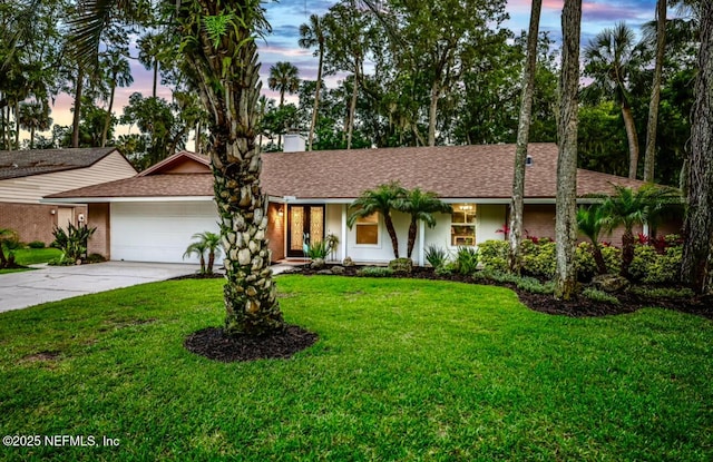 102 Granada Ln, Ponte Vedra Beach, FL 32082 - ranch-style house featuring a garage, a yard, concrete driveway, and a shingled roof