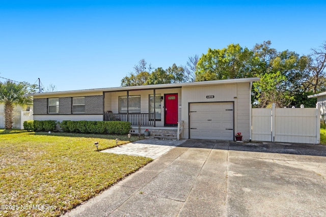 view of front of house featuring an attached garage, a gate, fence, driveway, and a front lawn