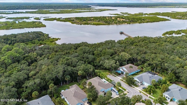 aerial view with a water view and a wooded view