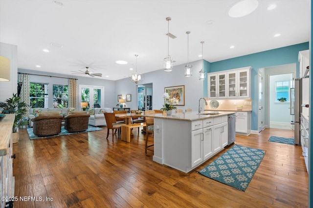 kitchen featuring an island with sink, hardwood / wood-style flooring, open floor plan, and a sink