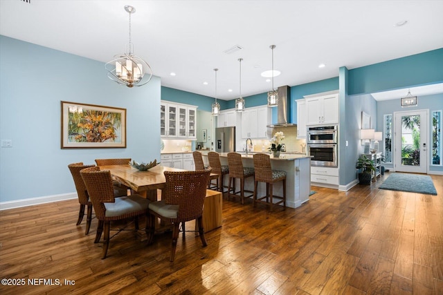 dining space with a chandelier, dark wood-type flooring, recessed lighting, and baseboards