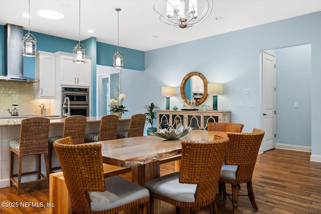 dining area with a chandelier, recessed lighting, dark wood finished floors, and baseboards