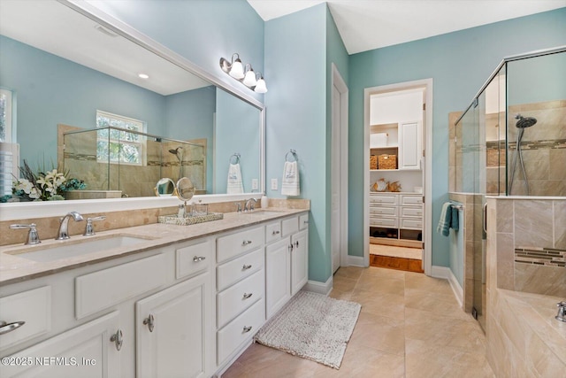 full bathroom featuring a stall shower, a sink, baseboards, and double vanity