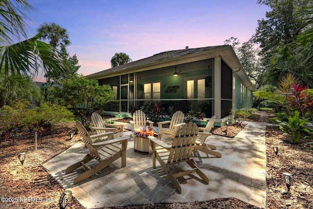 patio terrace at dusk with a sunroom and ceiling fan