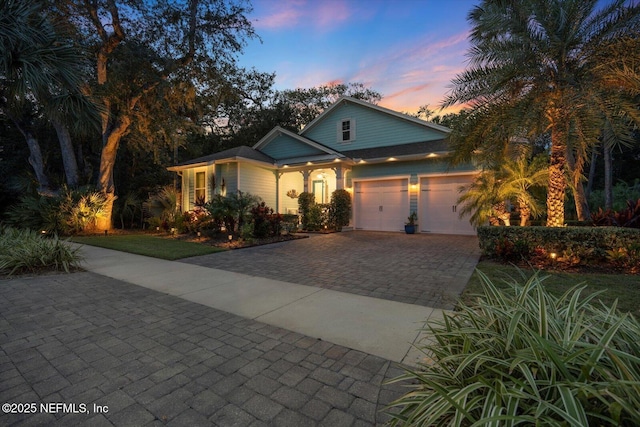 view of front of property featuring decorative driveway and an attached garage