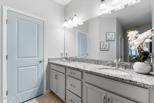 full bath featuring visible vents, a sink, and double vanity