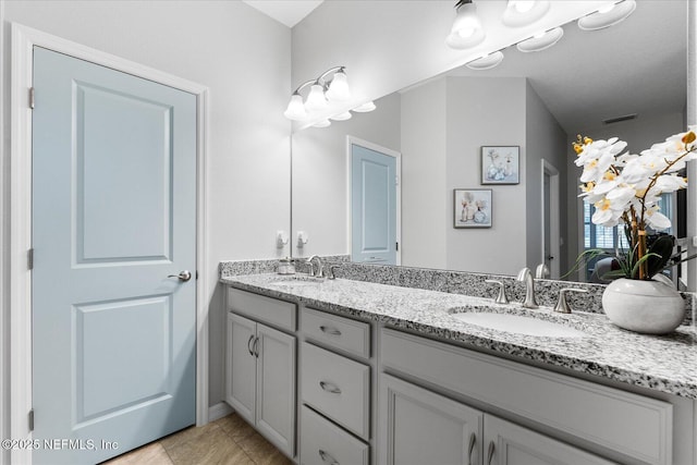 full bathroom featuring double vanity, visible vents, and a sink