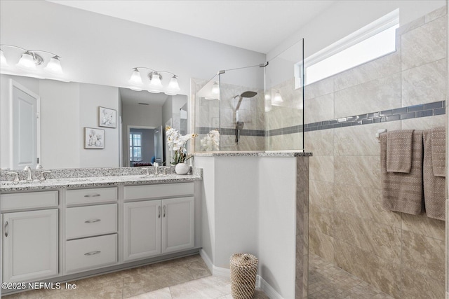 bathroom featuring double vanity, a sink, and walk in shower