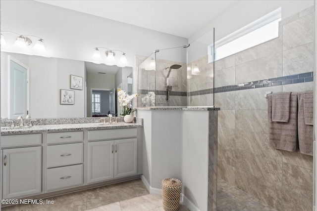 full bathroom featuring double vanity, a sink, and walk in shower