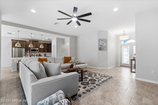 living room featuring baseboards, visible vents, and recessed lighting