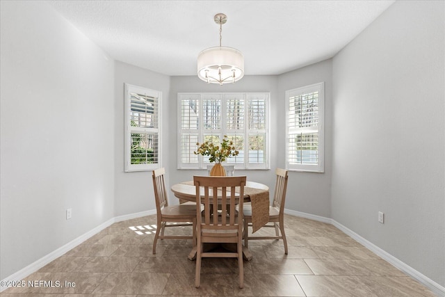 dining space with baseboards and light tile patterned floors