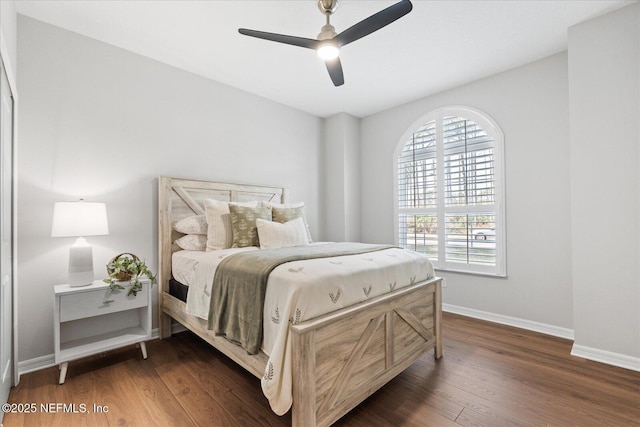 bedroom featuring dark wood-style floors, ceiling fan, and baseboards