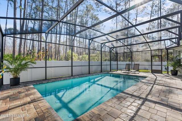 view of pool featuring a patio area, a fenced backyard, glass enclosure, and a fenced in pool