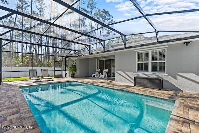 view of swimming pool featuring a ceiling fan, a fenced in pool, a patio, a lanai, and fence