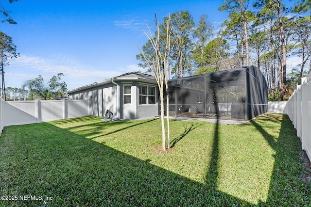 back of house with stucco siding, a fenced backyard, and a yard