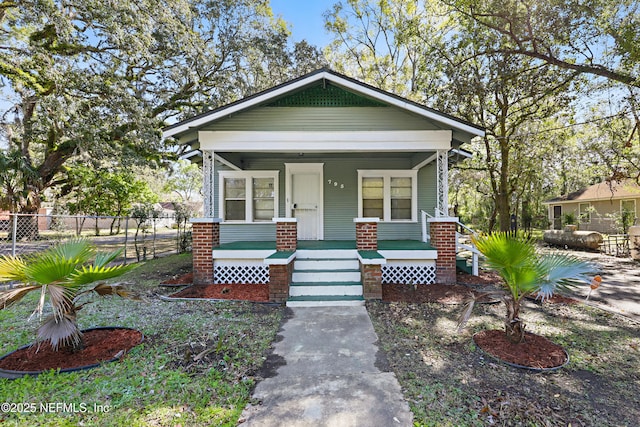 view of front of house featuring covered porch and fence